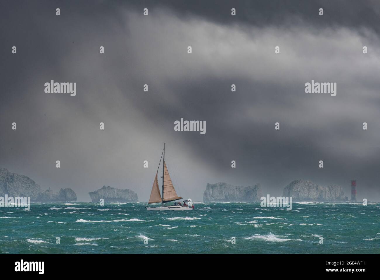 La voile dans le Solent juste au large des aiguilles de la côte de l'île de Wight sous un ciel arc-en-ciel et très grand ciel Banque D'Images