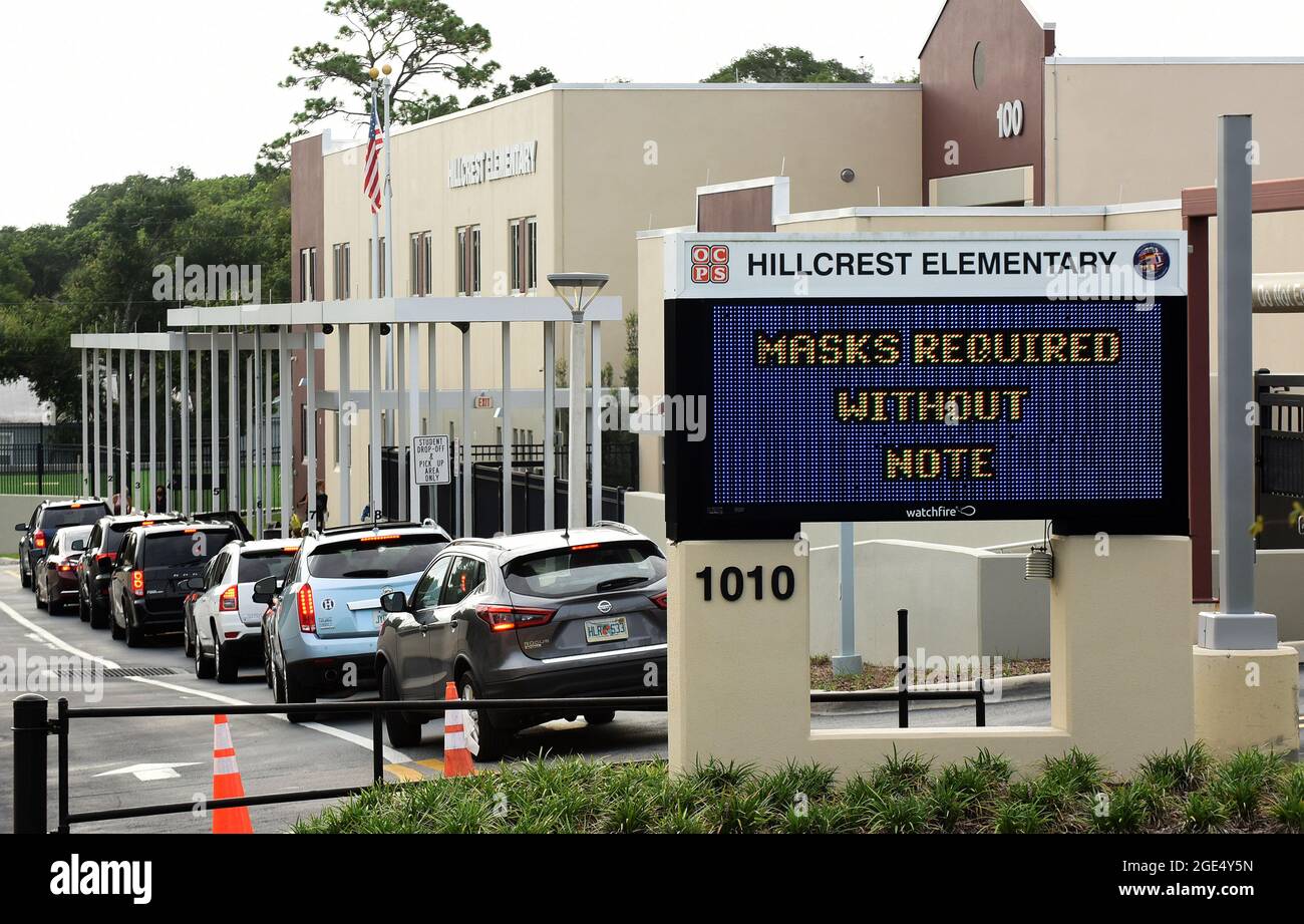 Orlando, États-Unis. 16 août 2021. Les parents abandonnent leurs enfants à l'école élémentaire Hillcrest d'Orlando avec un panneau à l'entrée indiquant l'exigence de masques pour les élèves, à moins que les parents ne se désabonnent du mandat en écrivant une note aux responsables de l'école. Les écoles publiques du comté d'Orange ont indiqué qu'environ 4 % des élèves ont soumis des notes pour se désister de l'exigence de masque facial du district le premier jour de l'école. Crédit : SOPA Images Limited/Alamy Live News Banque D'Images