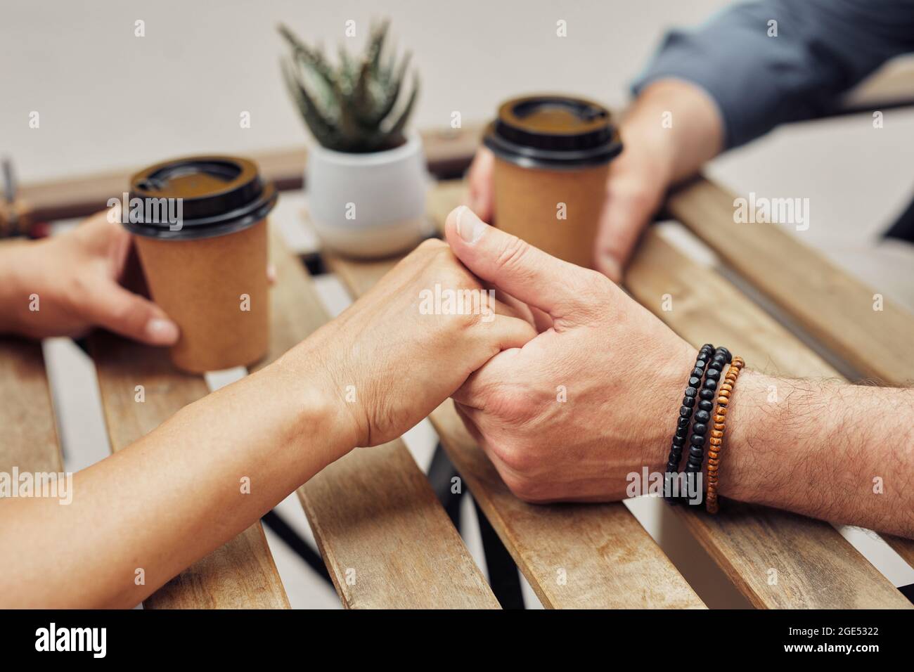 Gros plan d'un couple senior romantique tenant la main dans un café extérieur pendant la date, espace de copie Banque D'Images