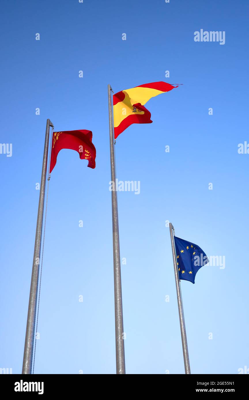 détail de certains drapeaux de l'europe, de l'espagne et de la région de murcie sur quelques mâts au-dessus du ciel bleu Banque D'Images