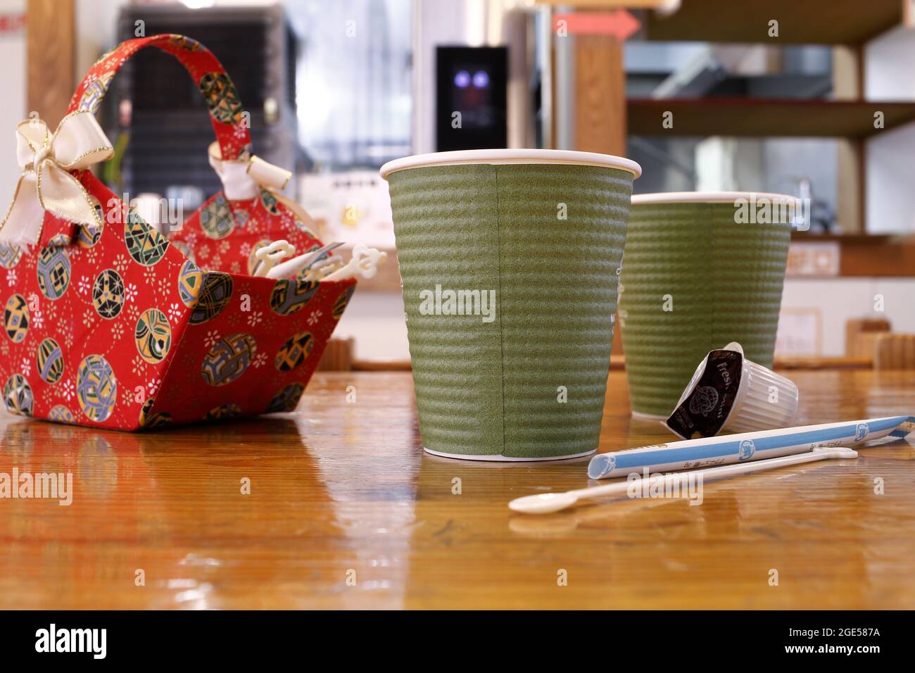 Nagano, Japon, 2021-10-08 , deux tasses en papier remplies de café, et un panier rouge aa avec sucre et crème. Banque D'Images