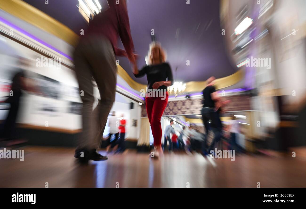 04 août 2021, Hessen, Francfort-sur-le-main: Les participants à un cours de Lindy Hop (Swing) s'exercent à l'école de danse Weber dans le quartier de Höchst (tourné avec une vitesse d'obturation plus longue et un effet de zoom). Les écoles de danse de Hesse enseignent à nouveau, mais la joie du nouveau départ est assombrie. Corona a durement frappé l'industrie. (À dpa 'plein de verve en demi-plein de cours') photo: Arne Dedert/dpa Banque D'Images
