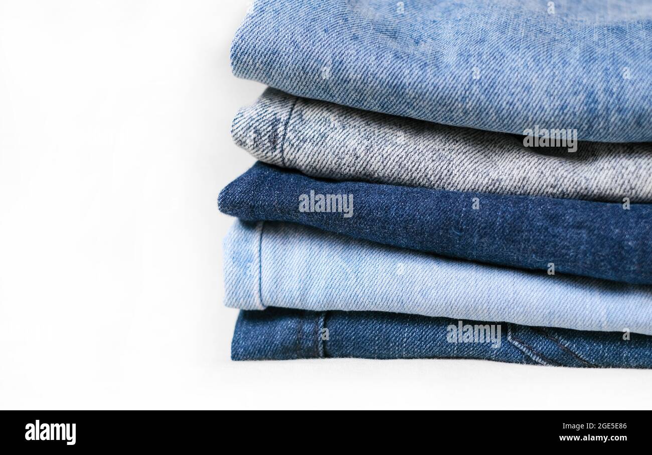 Texture jeans denim bleu. Utilisé différents jeans empilés dans un tas isolé sur fond blanc Banque D'Images