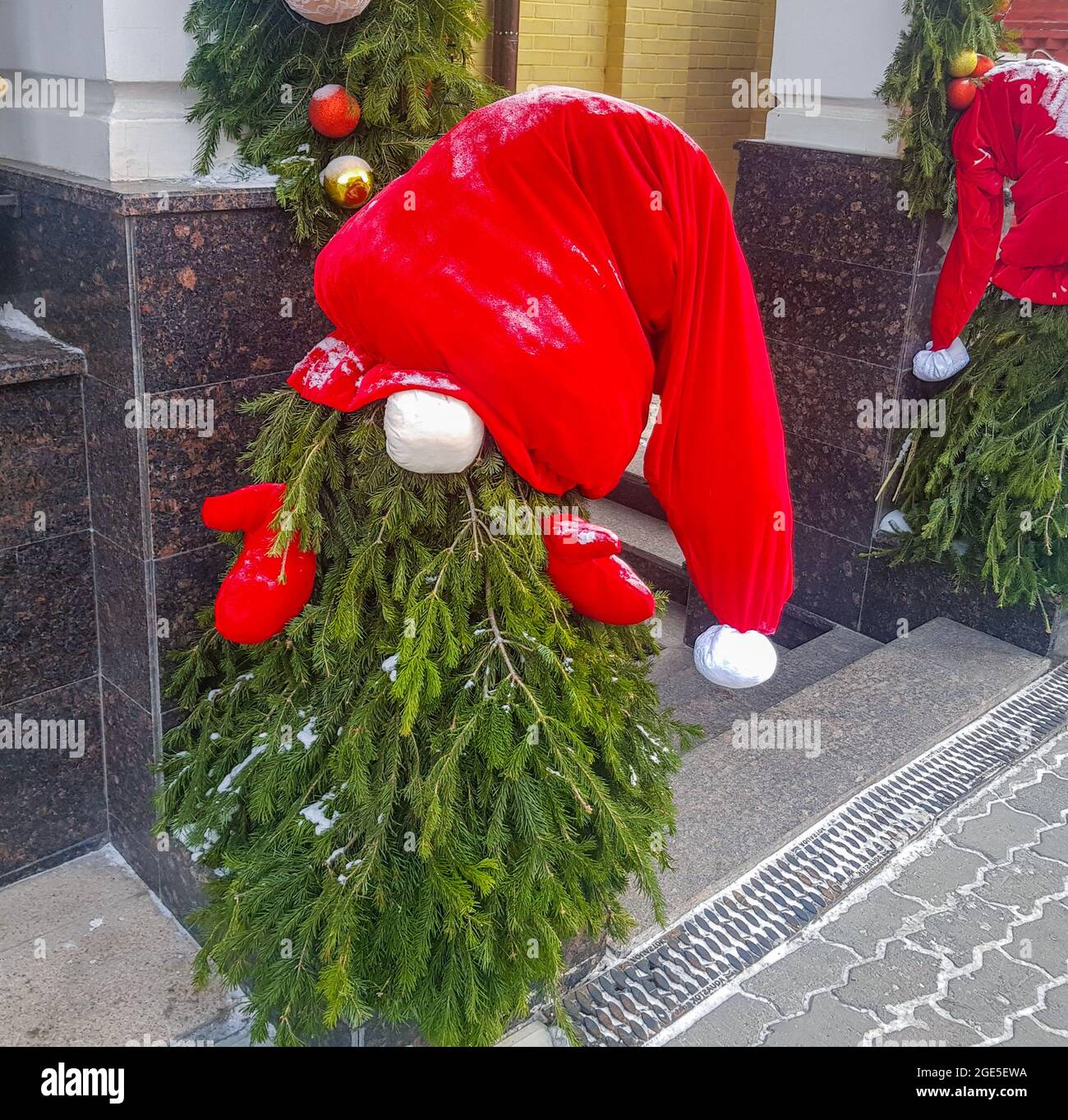 Un petit arbre de Noël est fait sous la forme du Père Noël avec un chapeau et des mitaines, dans l'ouverture à l'entrée du bâtiment, le concept de Christma Banque D'Images