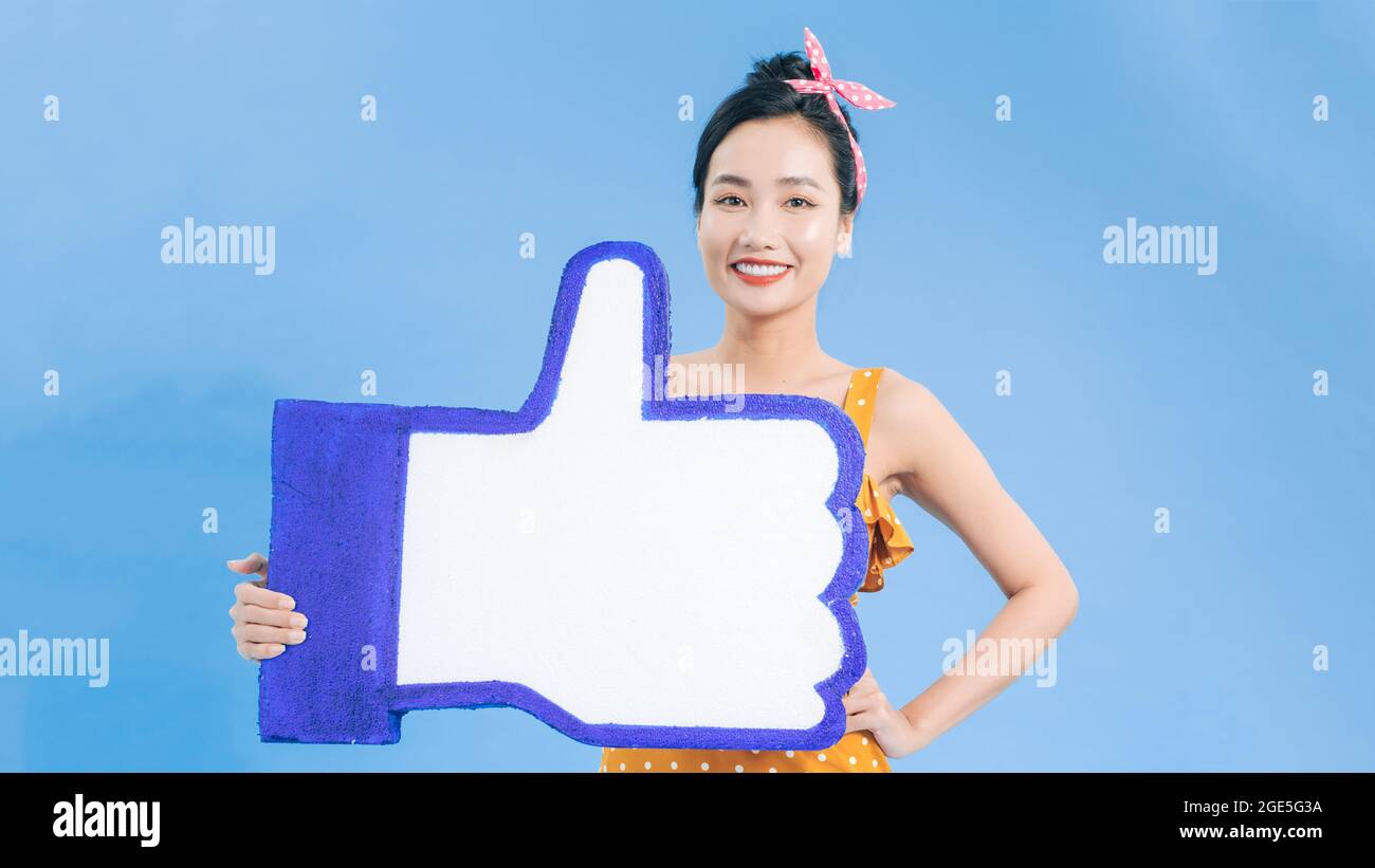 Bouton aimer. Bonne femme tenant le pouce vers le haut icône, symbole de notification de suiveur, recommandation et bon feedback dans les médias sociaux. Banque D'Images