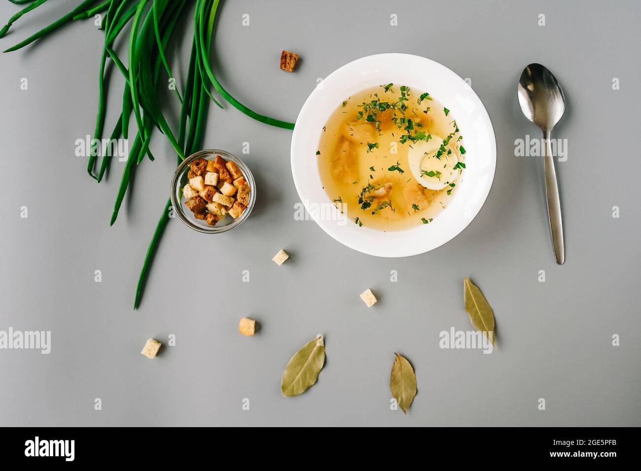 Soupe de nouilles de poulet avec légumes dans une assiette blanche. Cuillère, oignon vert et craquelins autour de l'assiette. Vue de dessus. Banque D'Images