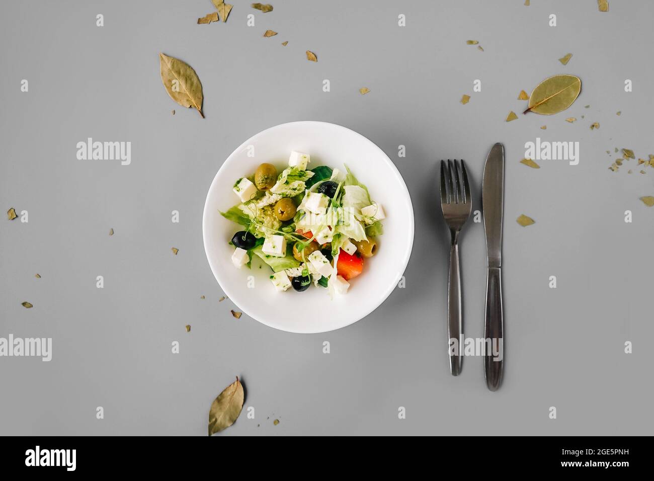 Salade grecque sur fond gris Uni. Microgreen frais sur salade. Banque D'Images