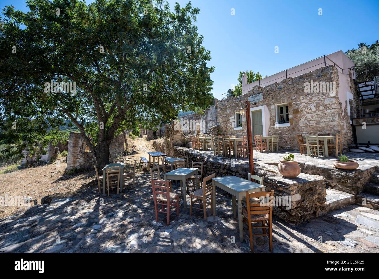Chaises et tables du restaurant Chaichutes, ville en ruines, village de montagne abandonné d'Agios Dimitrios, Kos, Grèce Banque D'Images