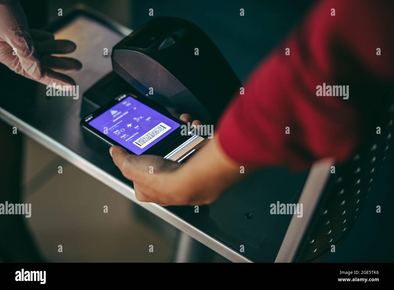 Une femme méconnaissable scanne un smartphone à l'arrivée à l'aéroport. Numérisation numérique sur la carte d'embarquement au comptoir d'enregistrement de l'aéroport. Banque D'Images