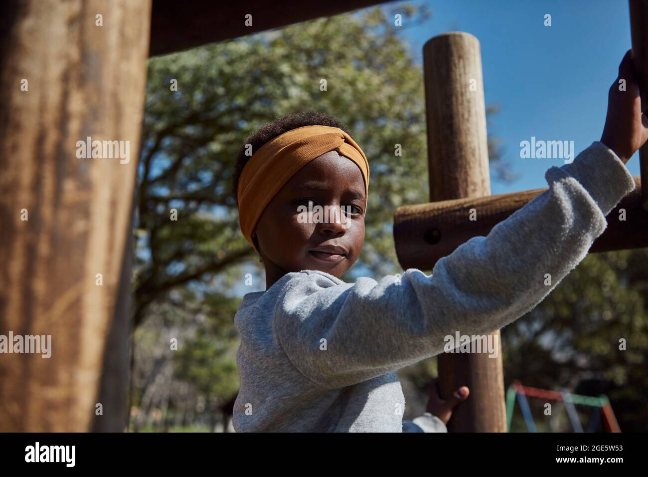 Belle fille africaine noire sur la jungle gym dans le parc Banque D'Images