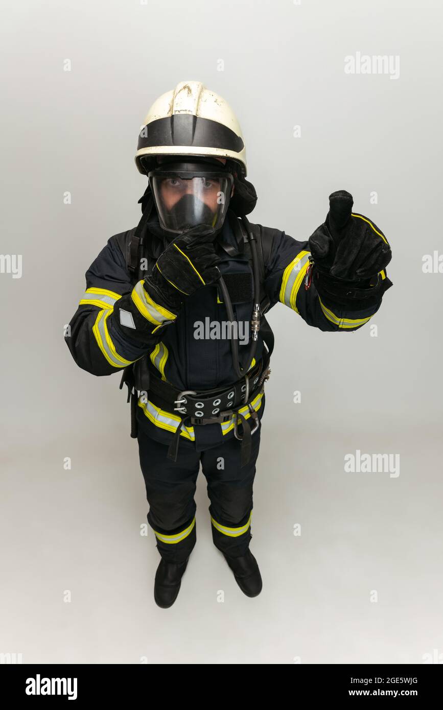 Un pompier vêtu d'uniforme posé sur fond blanc de studio. Banque D'Images