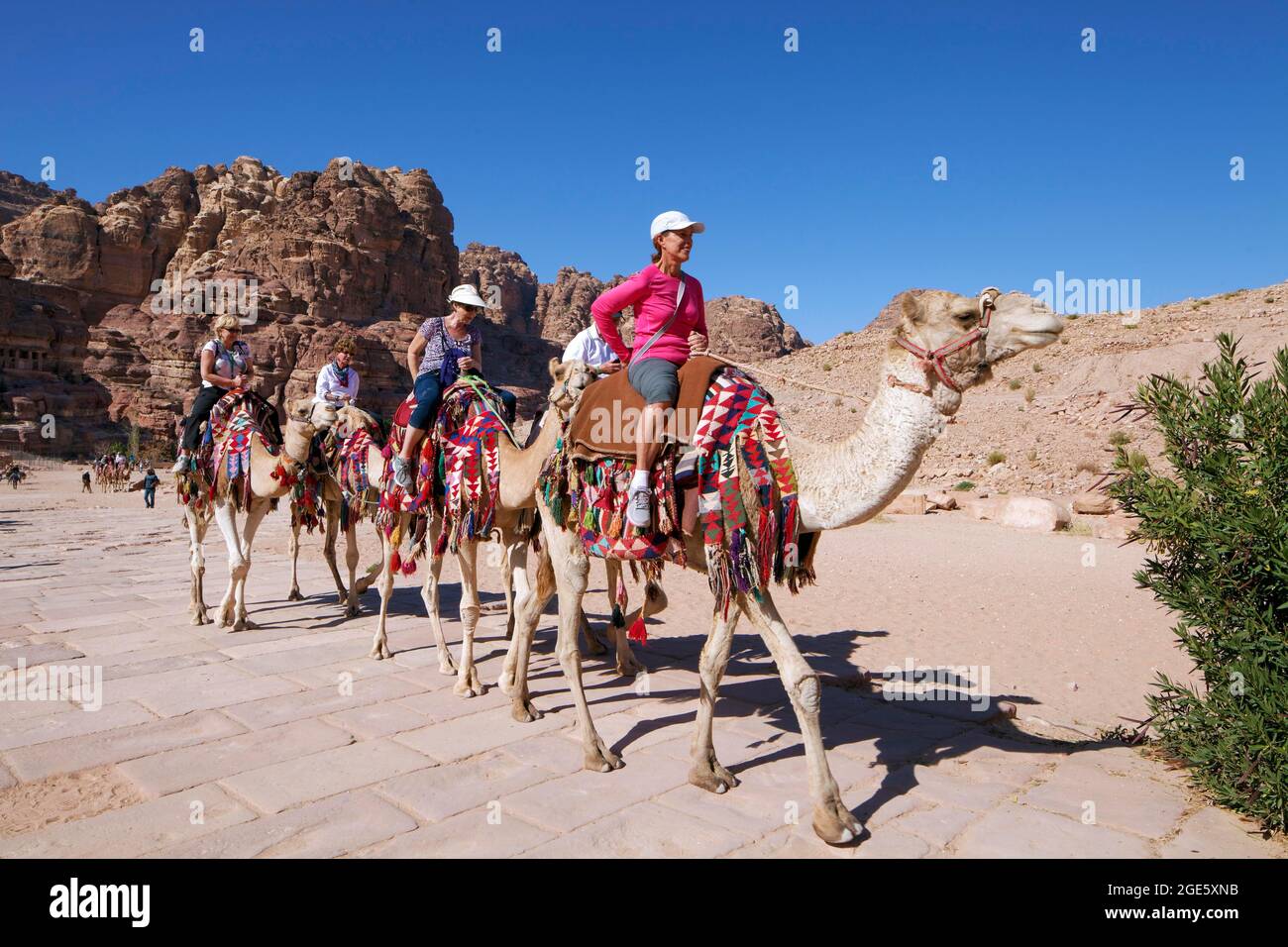 Touristes à cheval Camel (Camel dromedarius) sur la rue Colonnade, Petra, ancienne capitale des Nabatéens, site du patrimoine mondial de l'UNESCO, Royaume des Banque D'Images