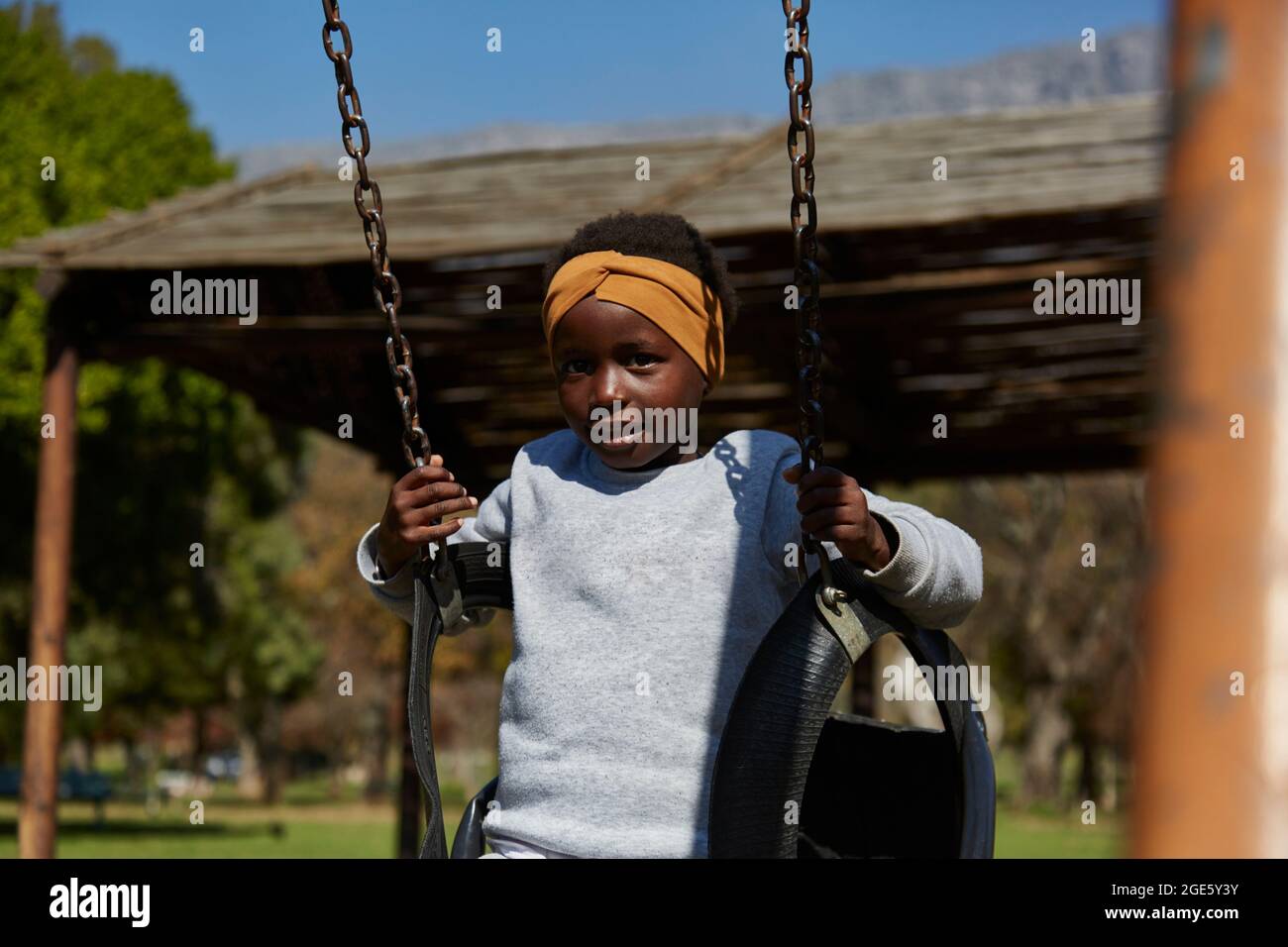 Belle fille africaine noire sur des balançoires dans le parc Banque D'Images