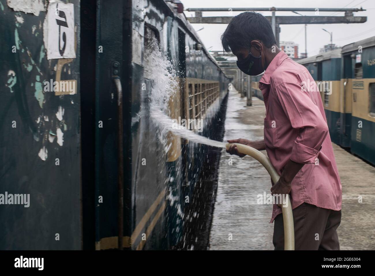 DHAKA, BANGLADESH - AOÛT 9 : un employé de chemin de fer nettoie un train à la gare de Kamalapur. Les services de transport public sur terre, sur rail et sur les voies navigables doivent reprendre leurs activités après la fin du confinement de Covid-19. Dimanche, la Division du Cabinet a publié une circulaire confirmant que le confinement strict national a été effectué à Dhaka, au Bangladesh, le 9 août 2021. Crédit : Groupe EYEPIX/accès photo Banque D'Images