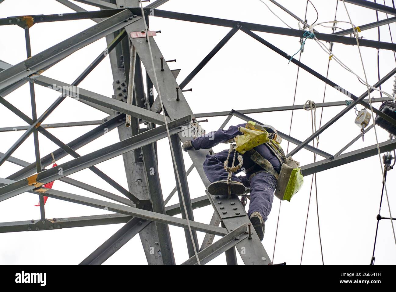 Hommes travaillant en hauteur, réaménageant des pylônes d'électricité, nord de l'Angleterre, Royaume-Uni Banque D'Images