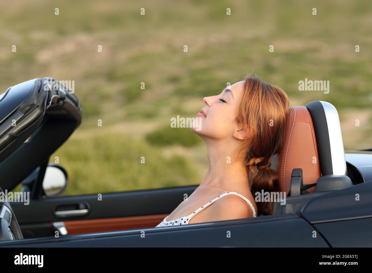 Profil d'une femme respirant de l'air frais dans une voiture convertible Banque D'Images