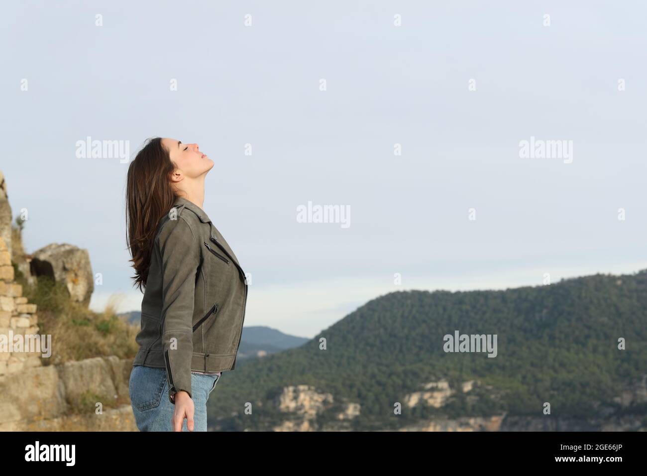 Profil d'une femme décontractée respirant de l'air frais dans la montagne Banque D'Images