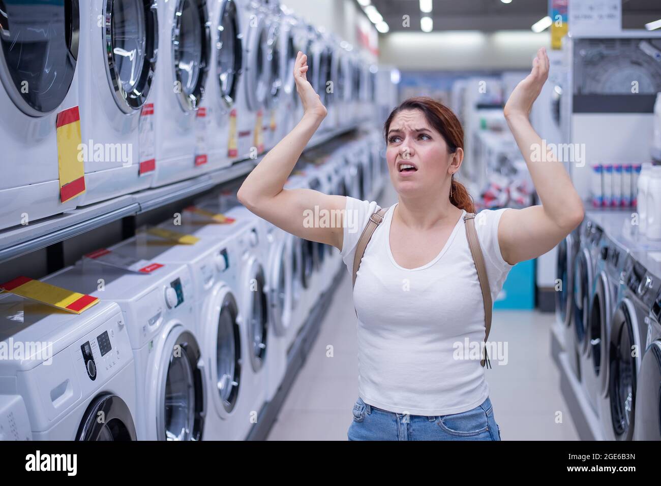 Une femme caucasienne choisit une machine à laver dans un magasin d'appareils ménagers Banque D'Images