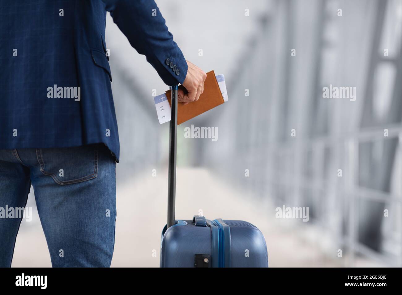 Concept de voyages aériens. Gros plan de l'homme avec passeport de retenue de valise et billets d'avion, voyageur masculin méconnaissable en attente d'embarquement Banque D'Images