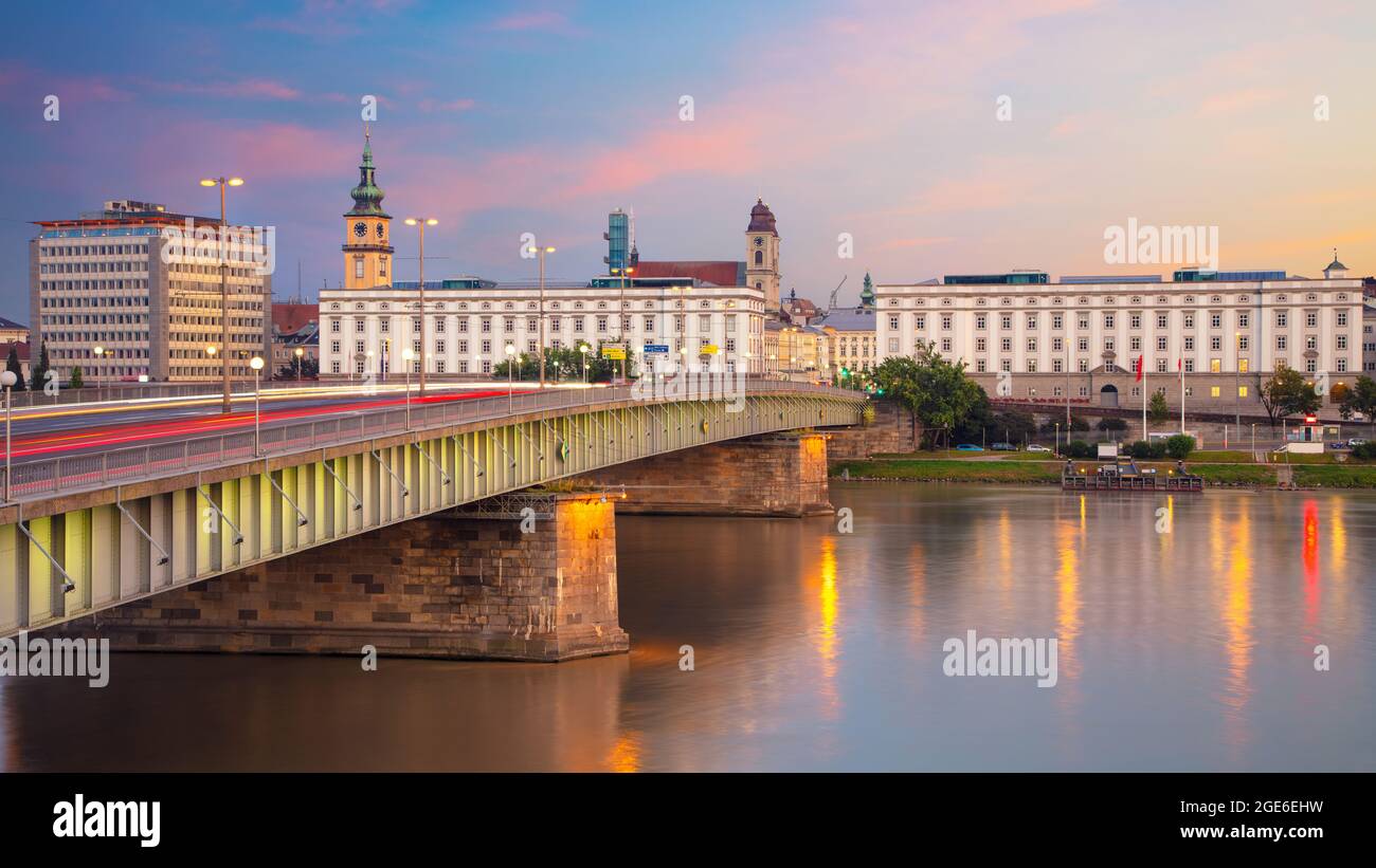 Linz, Autriche. Image panoramique du paysage urbain du bord de la rivière Linz, Autriche, au crépuscule de l'heure bleue, avec reflet des lumières de la ville sur le Danube. Banque D'Images