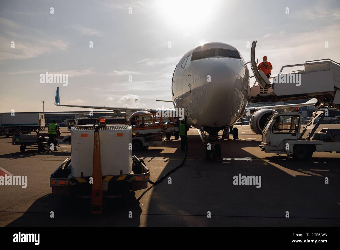 Les personnes se tenant près d'un grand avion moderne, le préparant pour l'embarquement dans le centre de l'aéroport en journée Banque D'Images