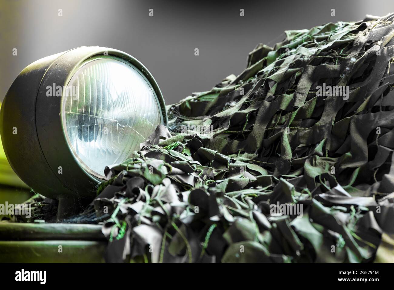 Vue rapprochée d'un véhicule militaire avec projecteur et filet de camouflage Banque D'Images