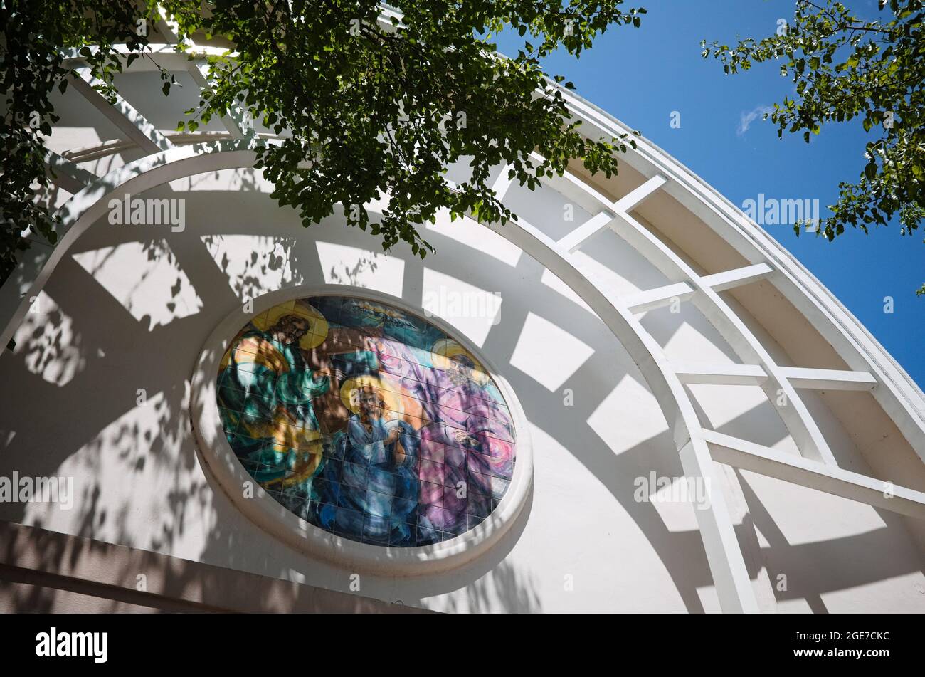 Arc jette l'ombre sur la mosaïque ronde avec des saints chrétiens au-dessus de l'entrée de l'église dans le style architectural moderne appelé Parroquia Asuncion de la Virgen Banque D'Images