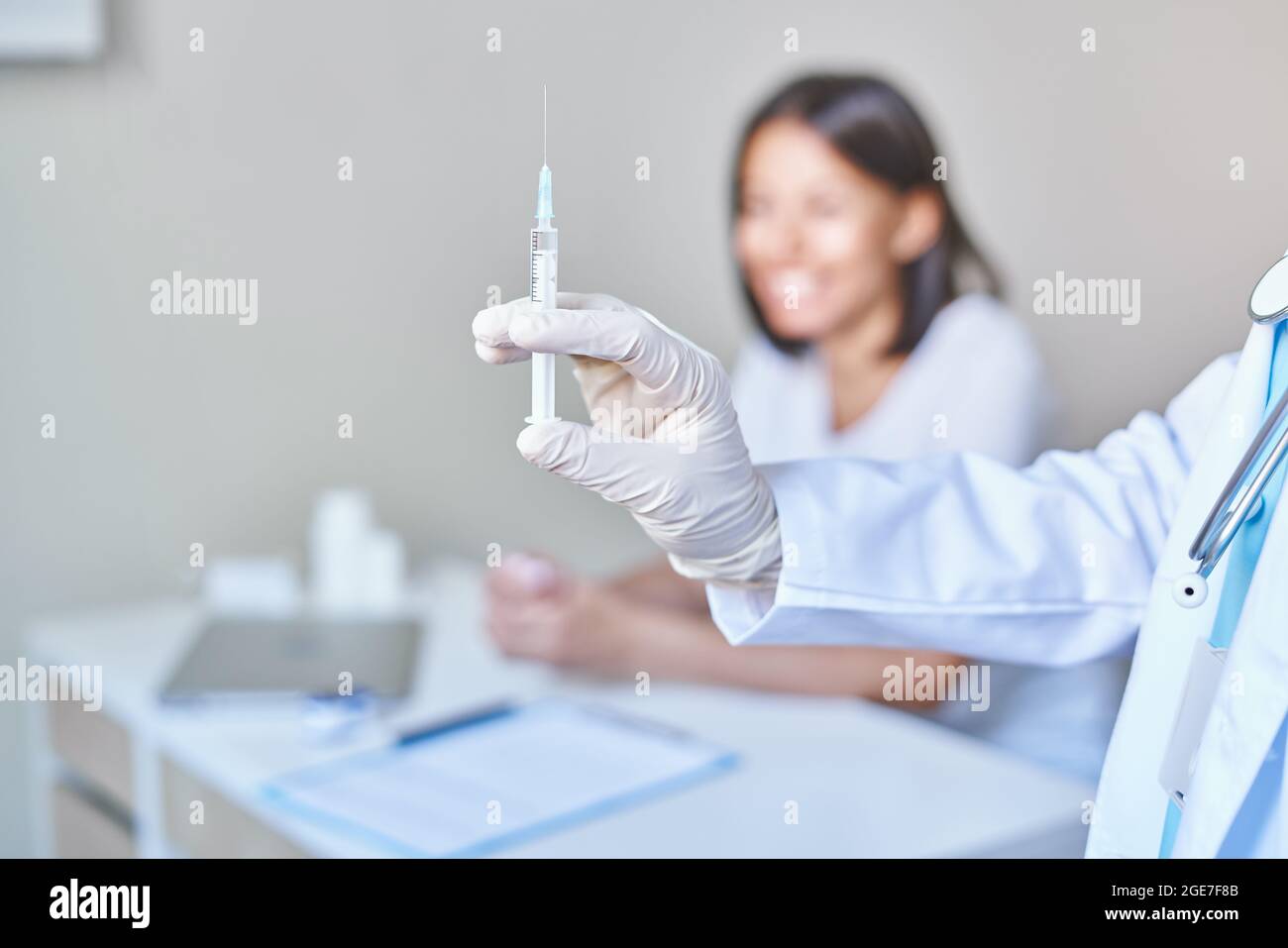 Médecin tenant une seringue avec le vaccin covid 19 coronavirus, prêt à vacciner la patiente africaine heureuse Banque D'Images