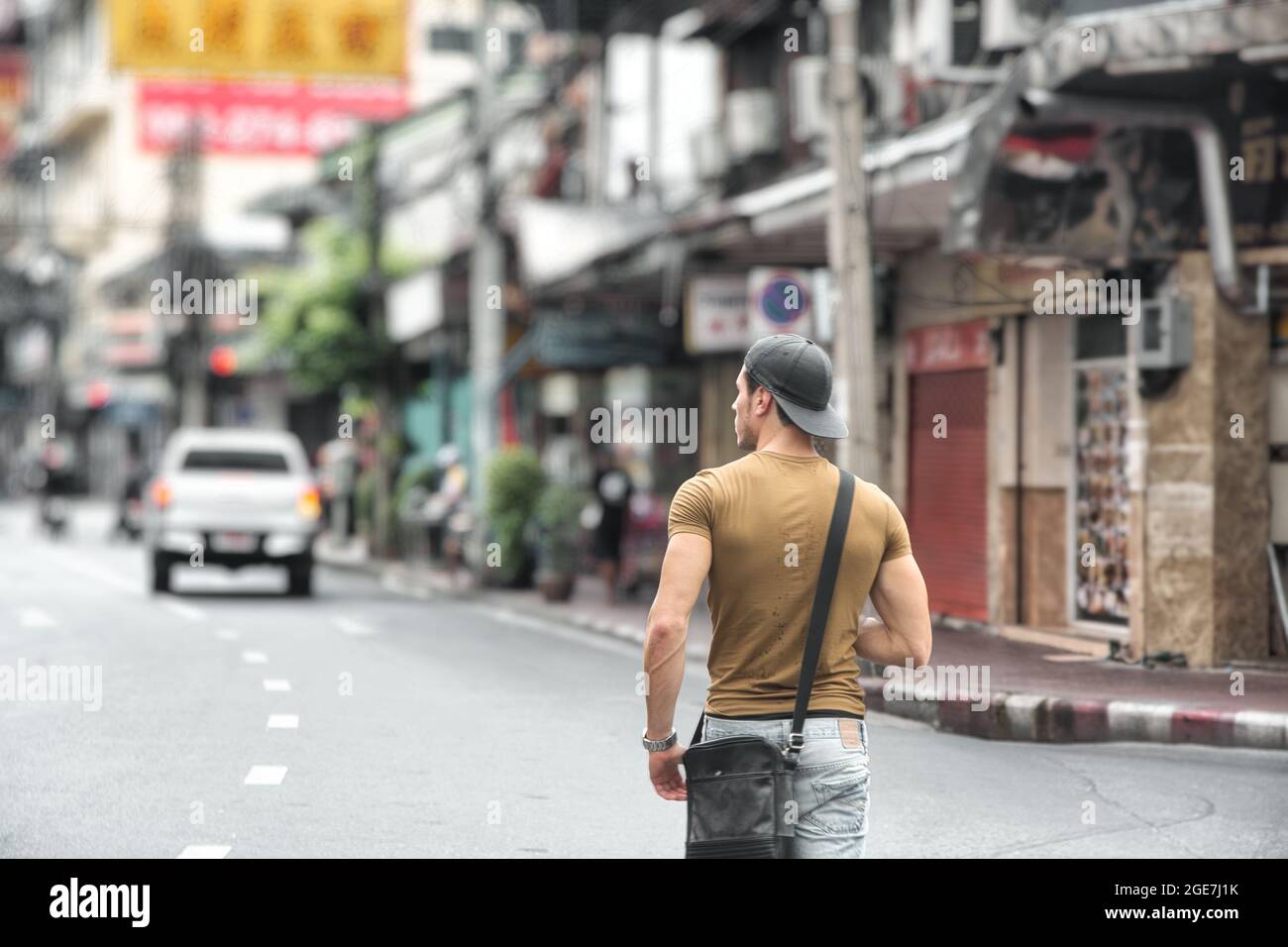 Vue arrière d'un jeune homme marchant à Bangkok, Thaïlande Banque D'Images
