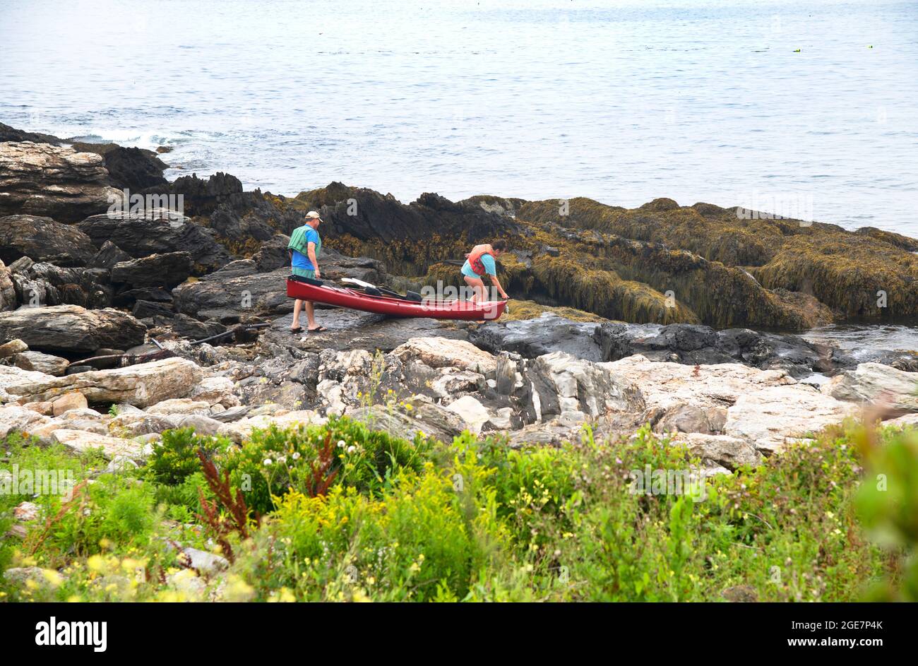 Un couple se prépare à lancer un kayak au large de la côte rocheuse d'East Boothbay, (Ocean point), Maine, États-Unis Banque D'Images