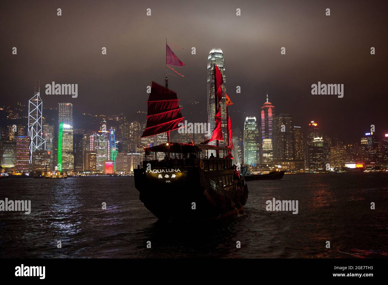 L'Aqualuna, un bateau chinois traditionnel dans le port de Victoria, avec la ligne d'horizon de l'île de Hong Kong en arrière-plan. Hong Kong, Chine Banque D'Images