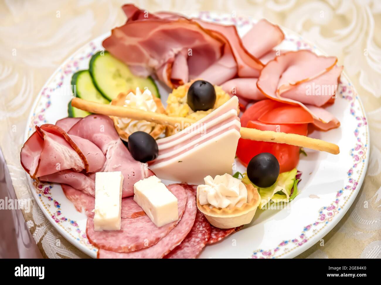 Assiette typique de hors-d'œuvre roumains qui ont des tomates farcies, concombre, fromage, pain de viande et de nombreux types de saucisses Banque D'Images