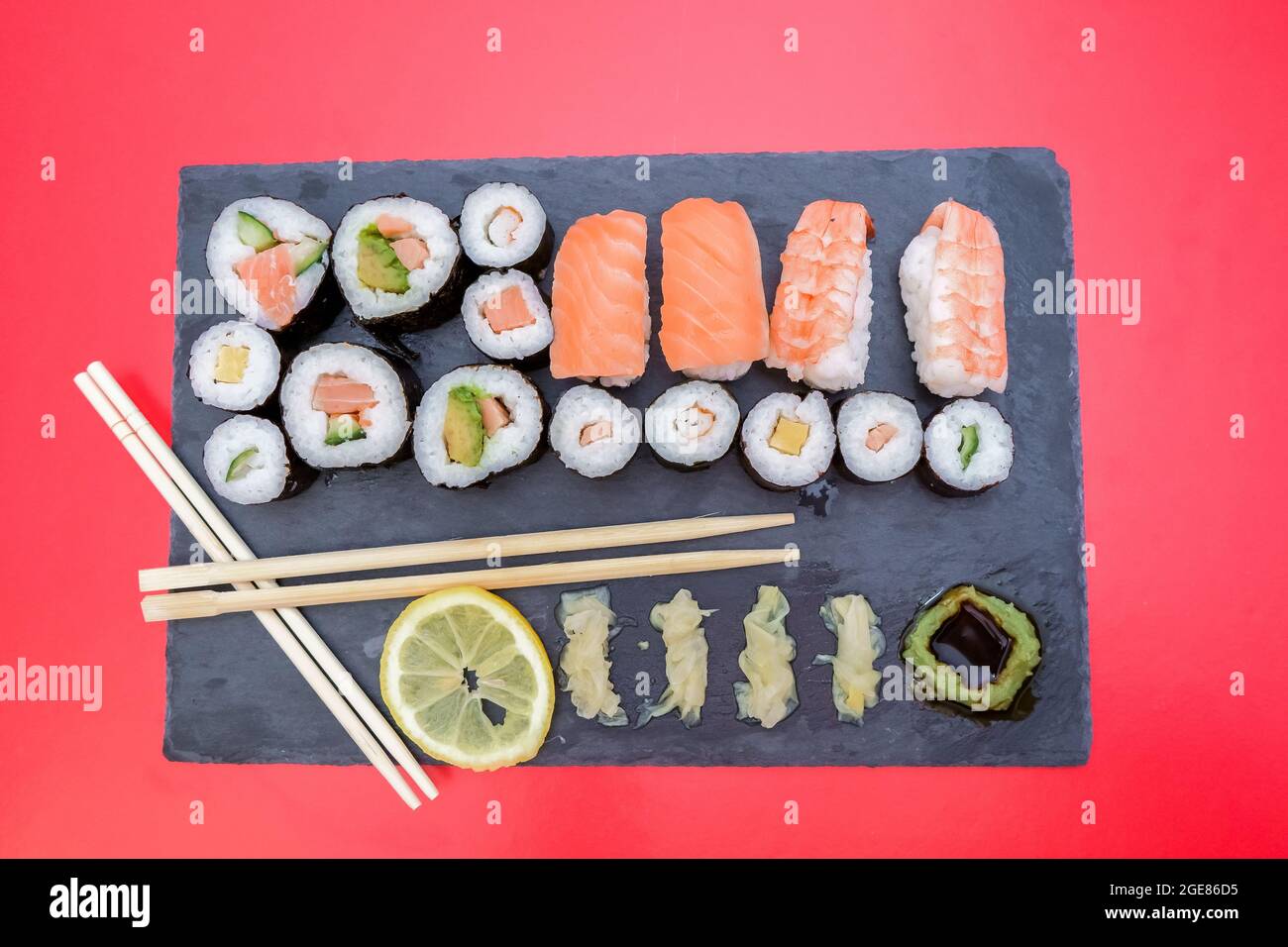 table en pierre avec de nombreuses variétés de sushis qui ont du saumon, des crevettes, de l'avocat, de l'œuf, du citron Banque D'Images