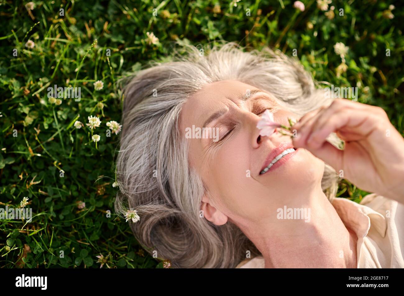 Gros plan sur le visage d'une femme allongé sur de l'herbe Banque D'Images