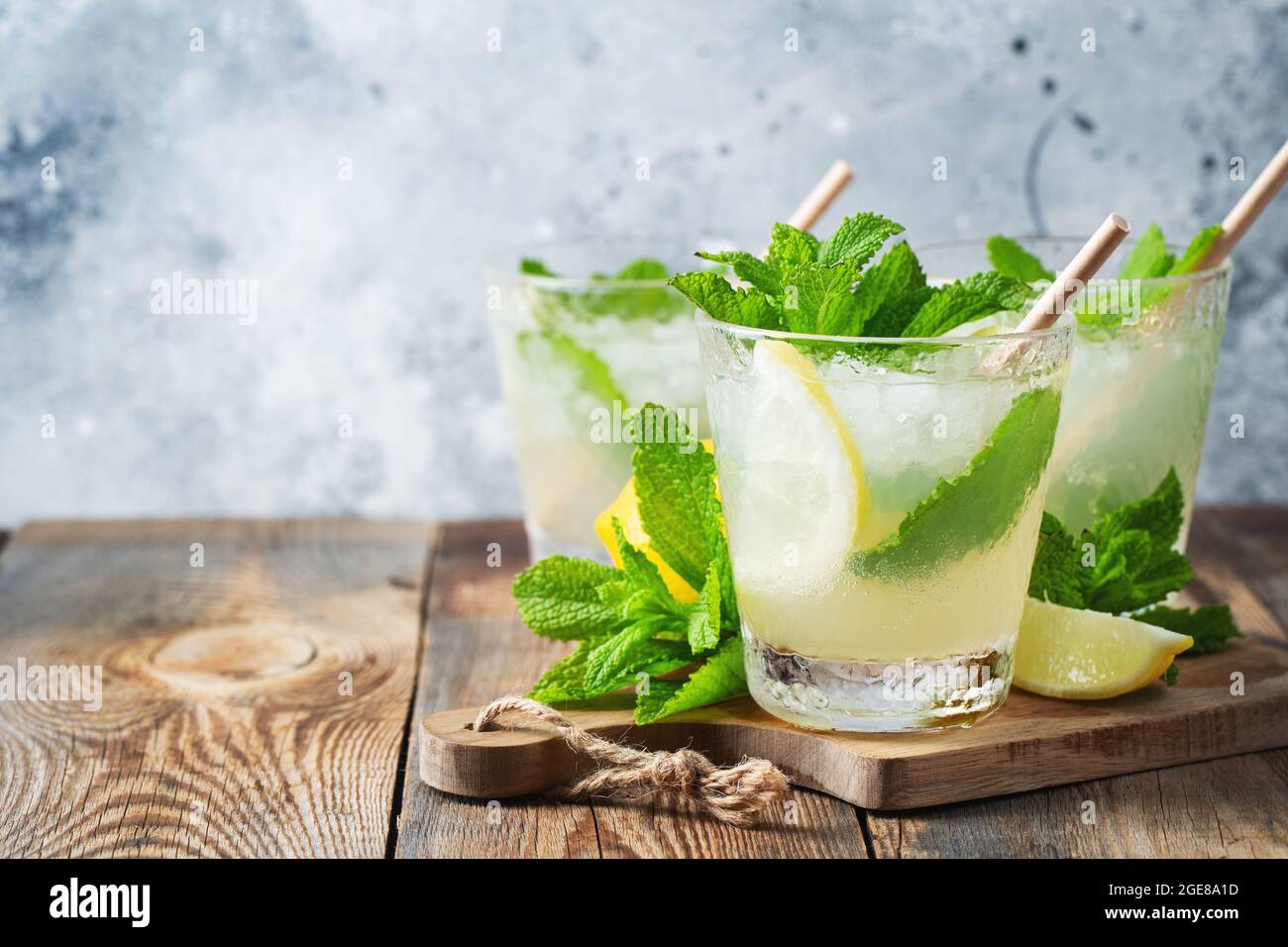 Deux verre avec limonade ou mojito cocktail au citron et à la menthe, boisson rafraîchissante ou une boisson froide avec de la glace sur fond bleu rustique. Copier l'espace. Banque D'Images