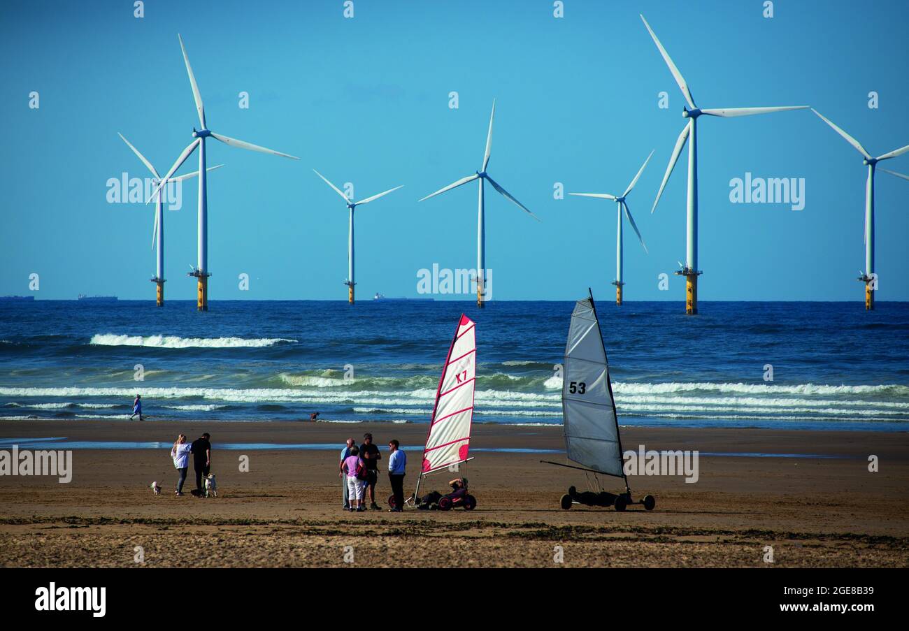 Promenade en buggy sur la plage avec Teesside Wind Farm, ou également appelée Redcar Wind Farm sur la plage de Coatham, côte nord-est de l'Angleterre, Royaume-Uni Banque D'Images