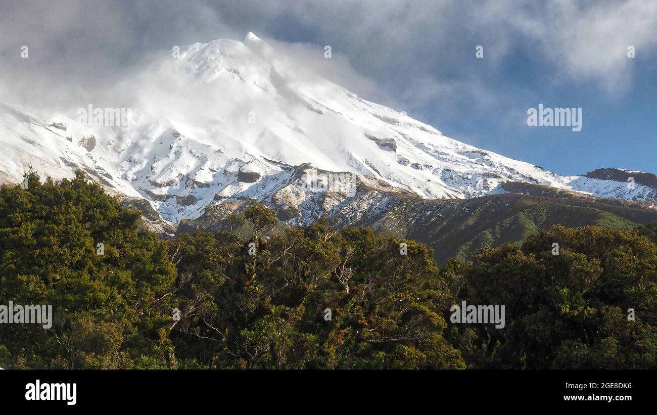 Des nuages de pluie traversent le côté est du mont Taranaki en hiver, depuis Dawson Falls. Parc national d'Egmont, Nouvelle-Zélande. Banque D'Images