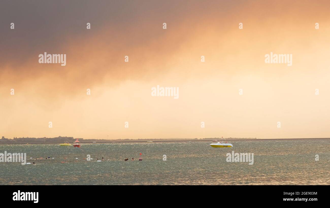 Fumée des feux de forêt qui s'élève sur une plage à Antalya, ville balnéaire de Manavgat en Turquie. Vue avec les gens sur la plage: Antalya, Manavgat Turquie - juillet Banque D'Images