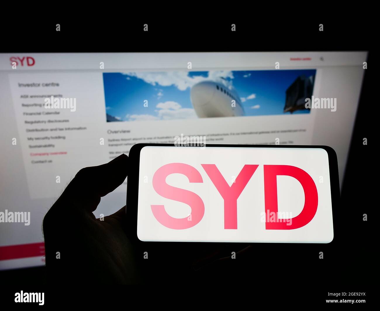 Personne tenant un téléphone portable avec le logo de la société australienne Sydney Airport Holdings Pty Ltd à l'écran devant la page Web. Mise au point sur l'affichage du téléphone. Banque D'Images