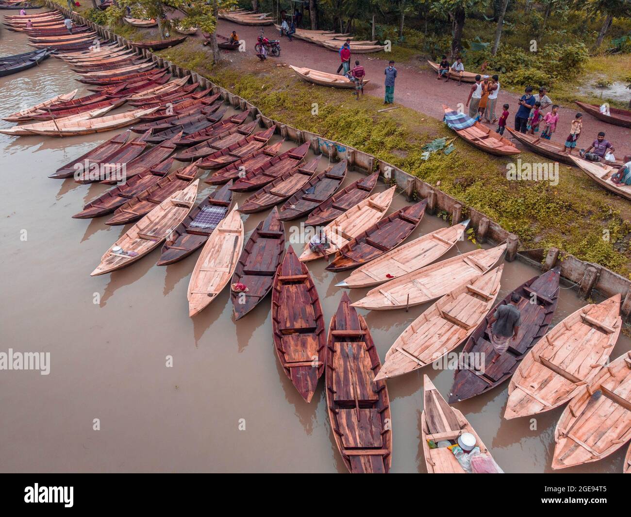 Barishal, Barishal, Bangladesh. 18 août 2021. Les constructeurs de bateaux de l'hebdomadaire 'Noukar Haat' (marché de bateaux) à Kuriana, sous la direction de Swarupkathi upazila du district de Pirojpur dans la division Barishal au Bangladesh, font des affaires de vive pendant cette saison de la Monsoon. Le marché de deux kilomètres de long est réputé pour le commerce de différentes variétés de bateaux pendant la saison de la mousson. Le marché se déroule tous les vendredis de mai à novembre. 'Panis'' ou 'Pinis'', 'ingi' et 'Naak Golui'' sont les types de bateaux disponibles à la vente, construits par des artisans locaux des Muktahar, Chami, Boldia, Inderhaat, B. Banque D'Images