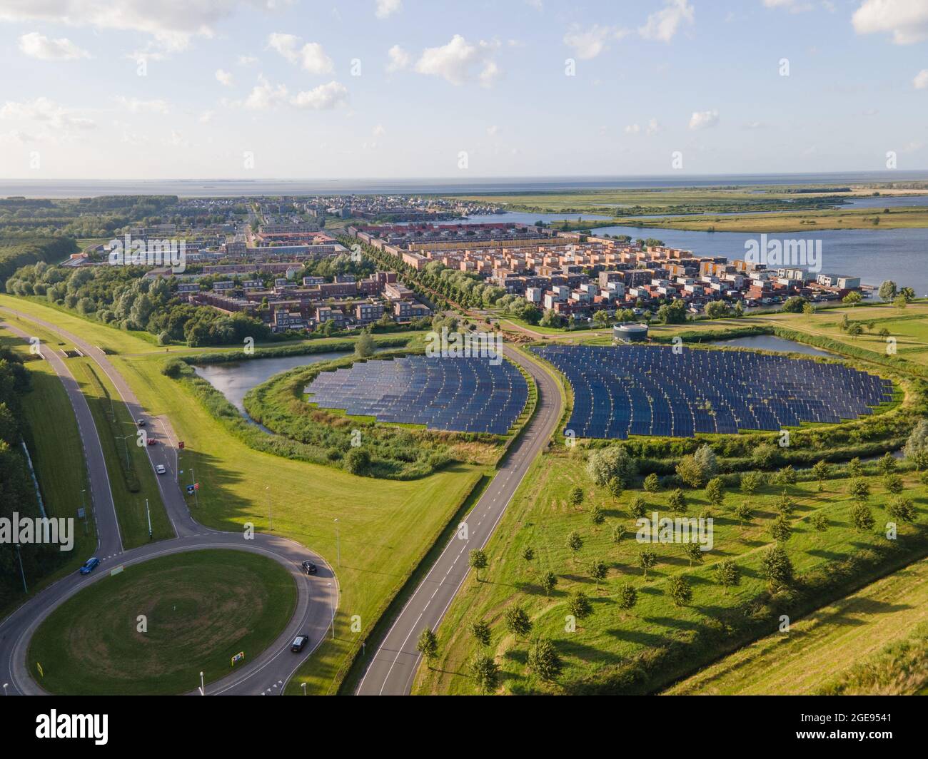 Quartier résidentiel moderne et innovant d'Almere, le long du bord de l'eau, avec champ de panneaux solaires. Pays-Bas, Flevoland. Banque D'Images