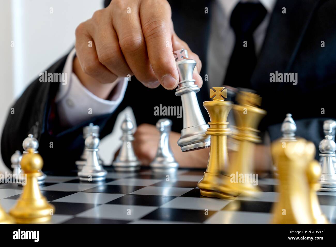La main d'homme d'affaires déplacer un roi d'or échecs pour forcer à l'argent échecs chute concept affaires gagner la victoire dans les batailles de la guerre commerciale Banque D'Images