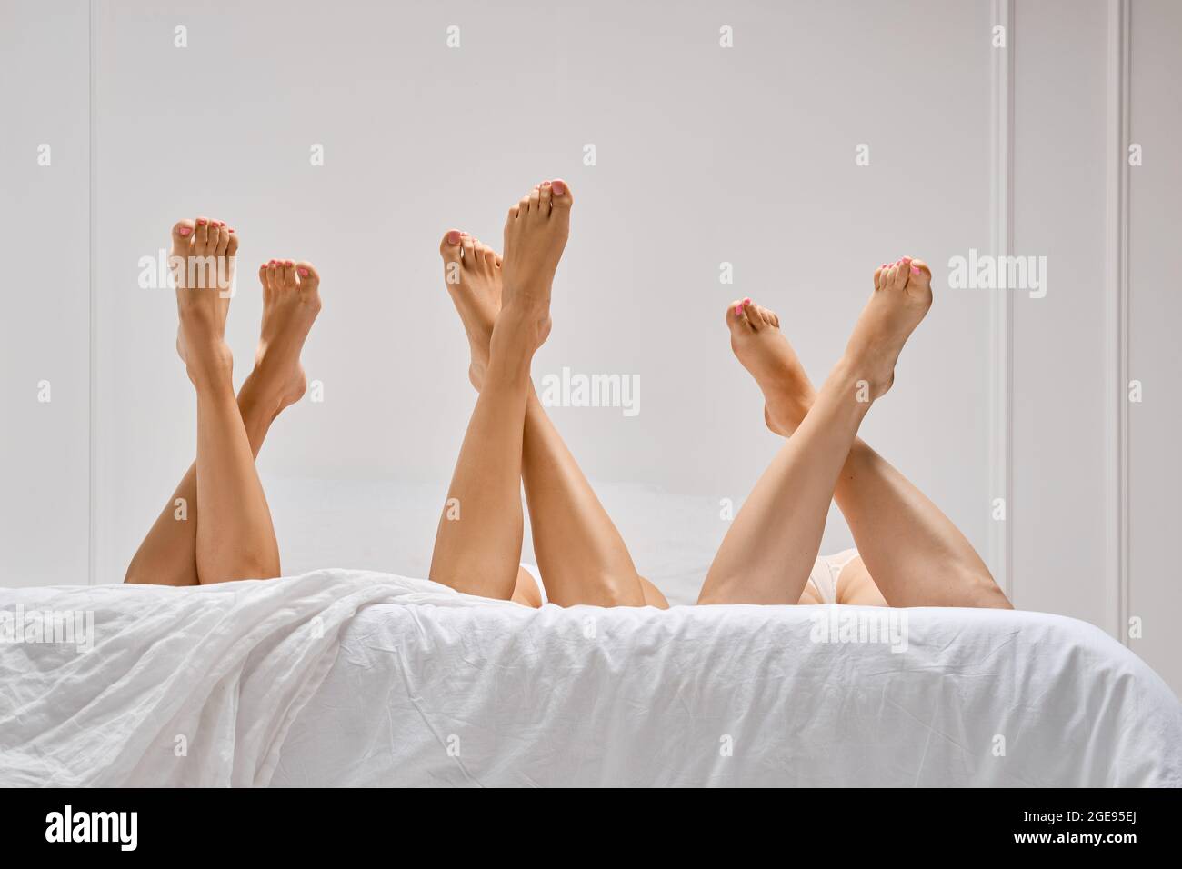 Vue à angle bas de trois paires croisées jambes femelles dans le lit Banque D'Images