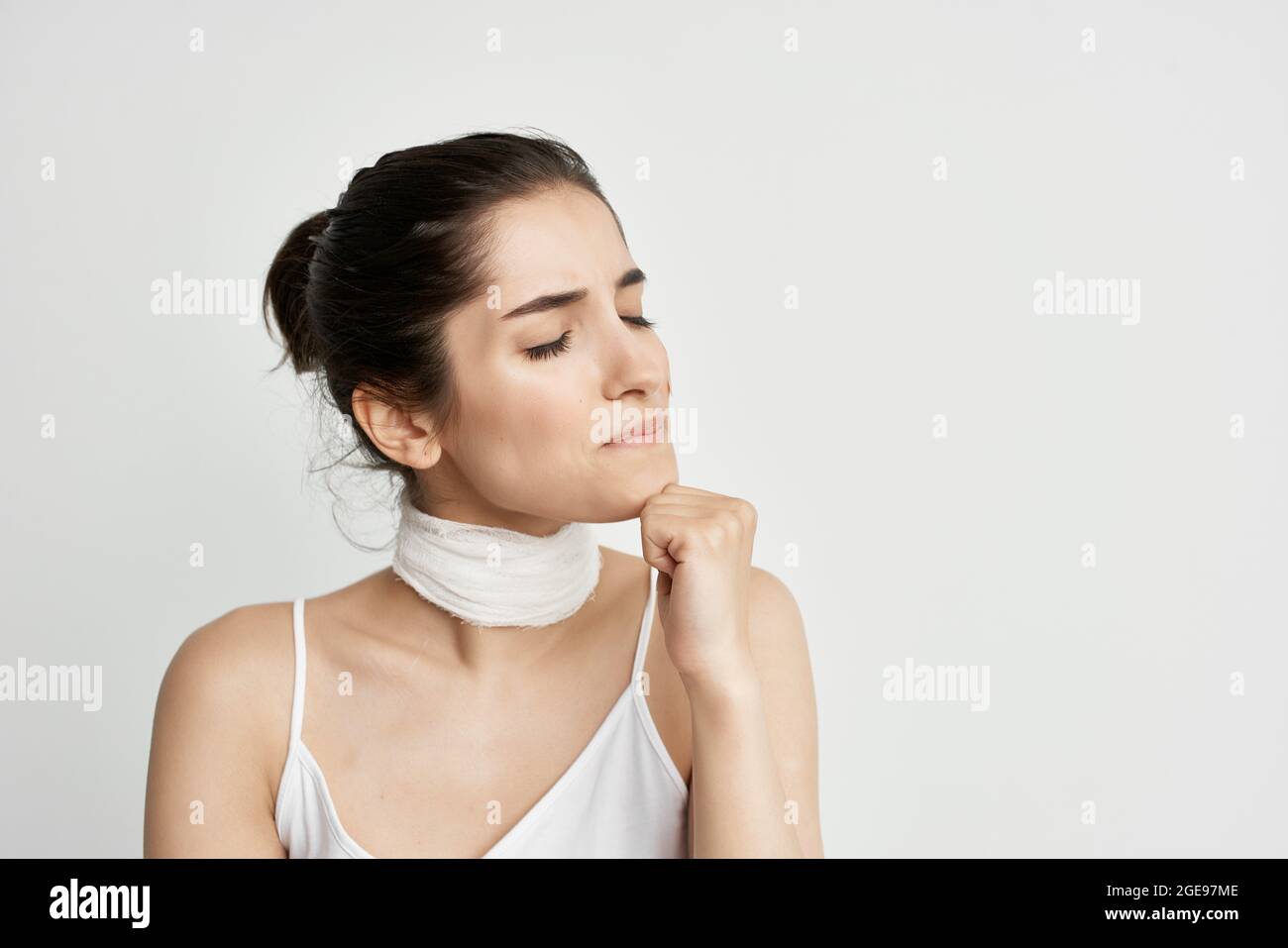 femme en t-shirt blanc avec un bandage autour de son cou mal de tête de  santé problème Photo Stock - Alamy