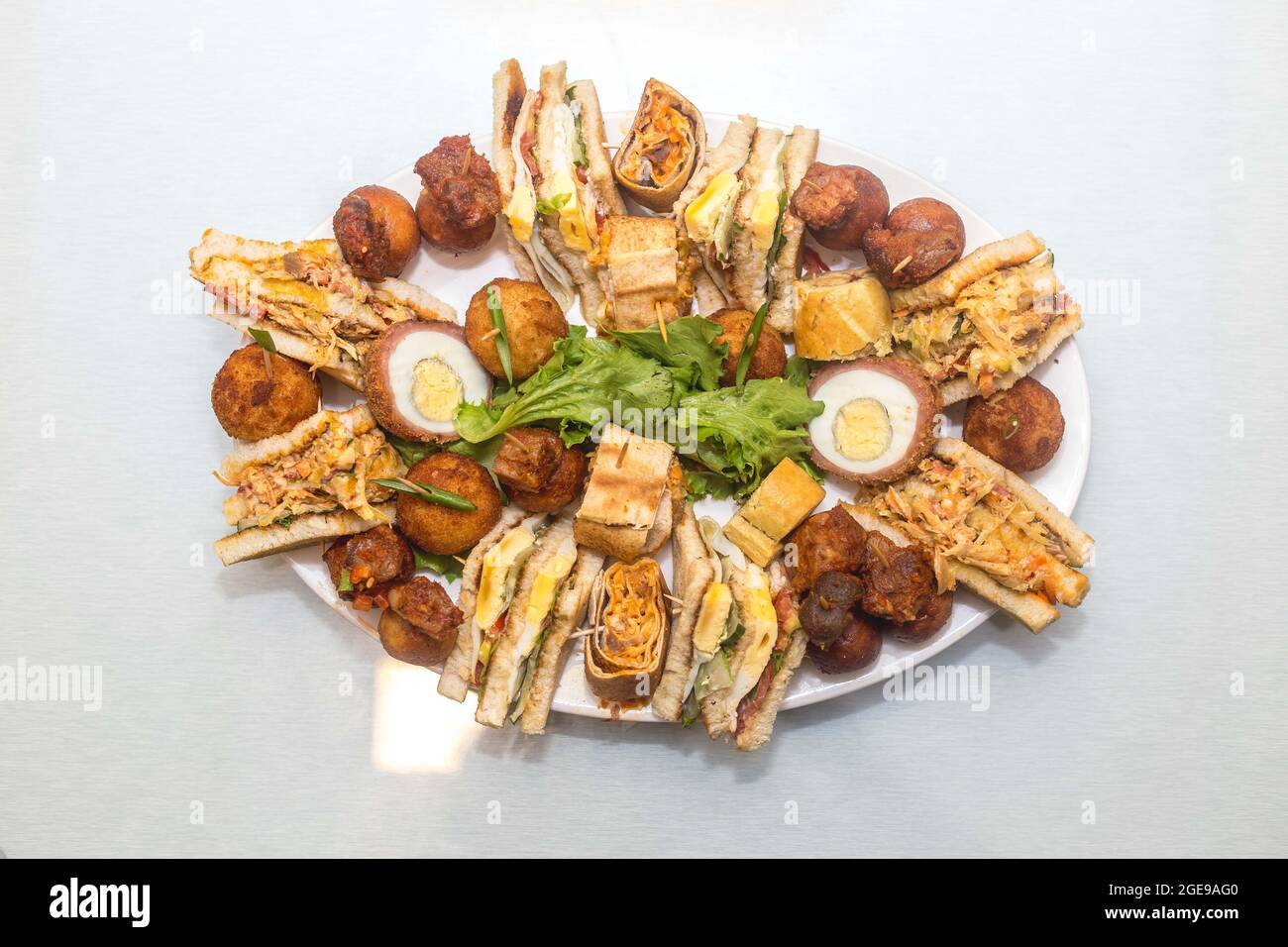 Repas combinés composés de gâteaux en tranches, d'œufs de scotch, de petits côtelettes avec des garnitures de brocoli de légumes Banque D'Images