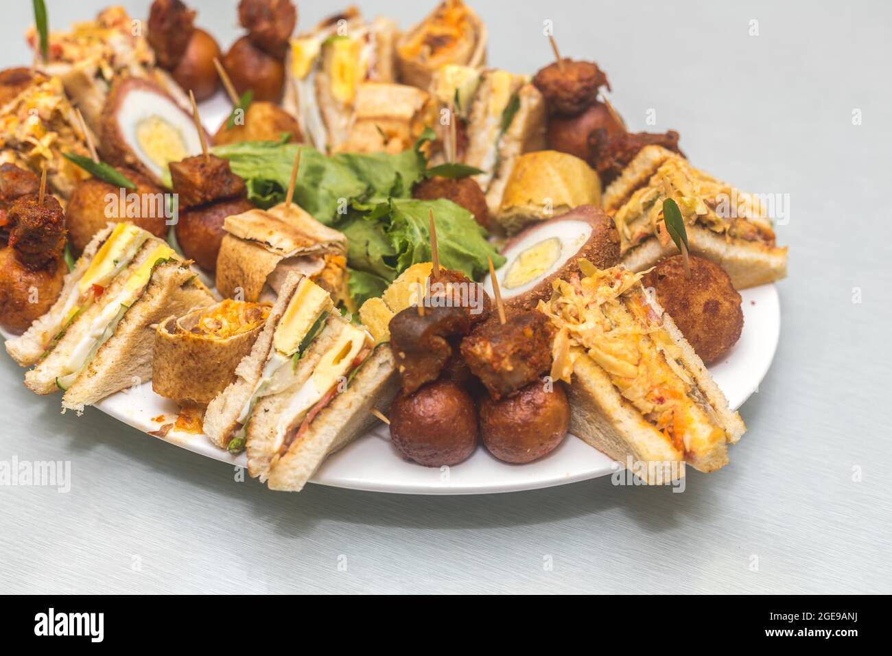 Repas combinés composés de gâteaux en tranches, d'œufs de scotch, de petits côtelettes avec des garnitures de brocoli de légumes Banque D'Images