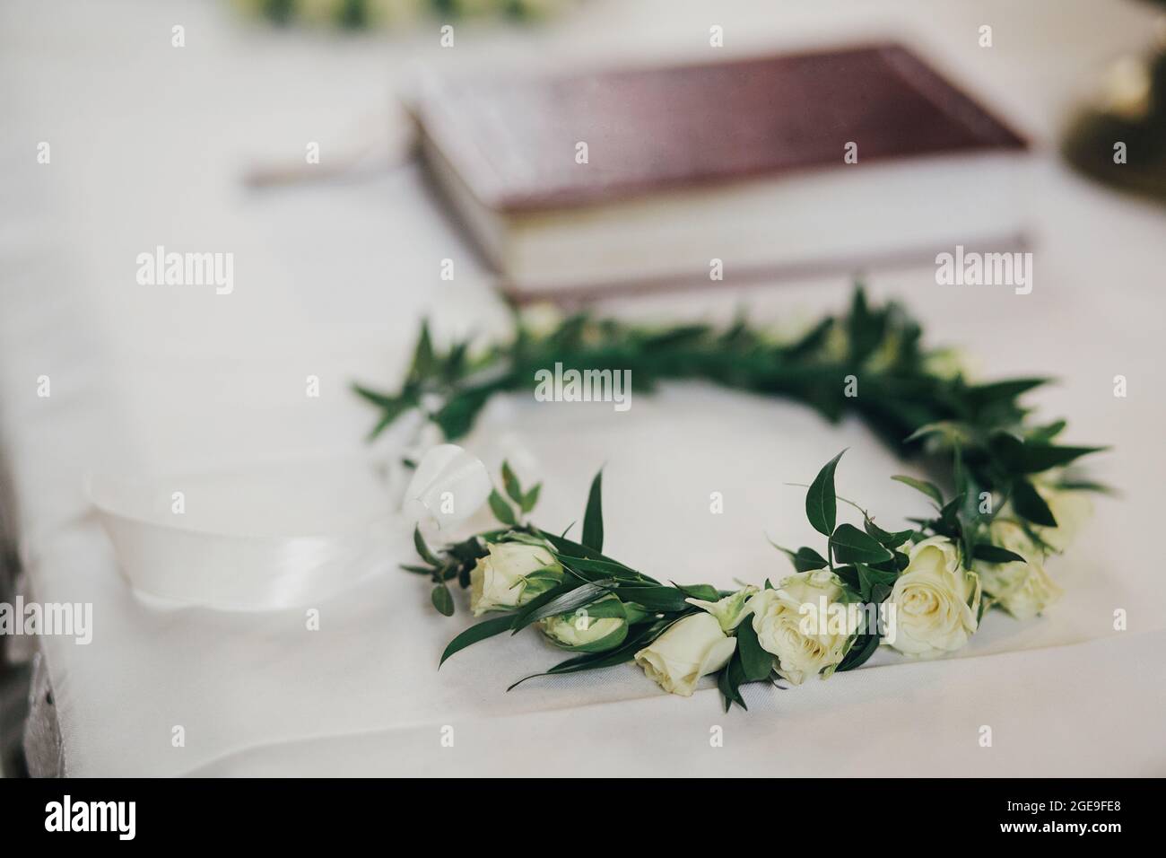 Belle couronne florale moderne avec roses sur nappe blanche sur autel dans l'église pour le mariage Saint. Cérémonie de mariage dans la cathédrale. Corbeau fleuri moderne Banque D'Images