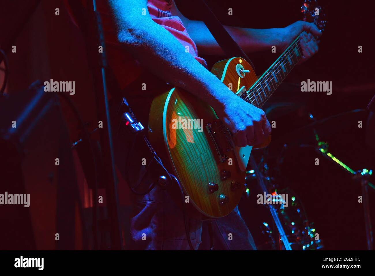 Le guitariste joue sa guitare sous les projecteurs. Mains d'un guitariste jouant de la guitare. Touche Bas Banque D'Images