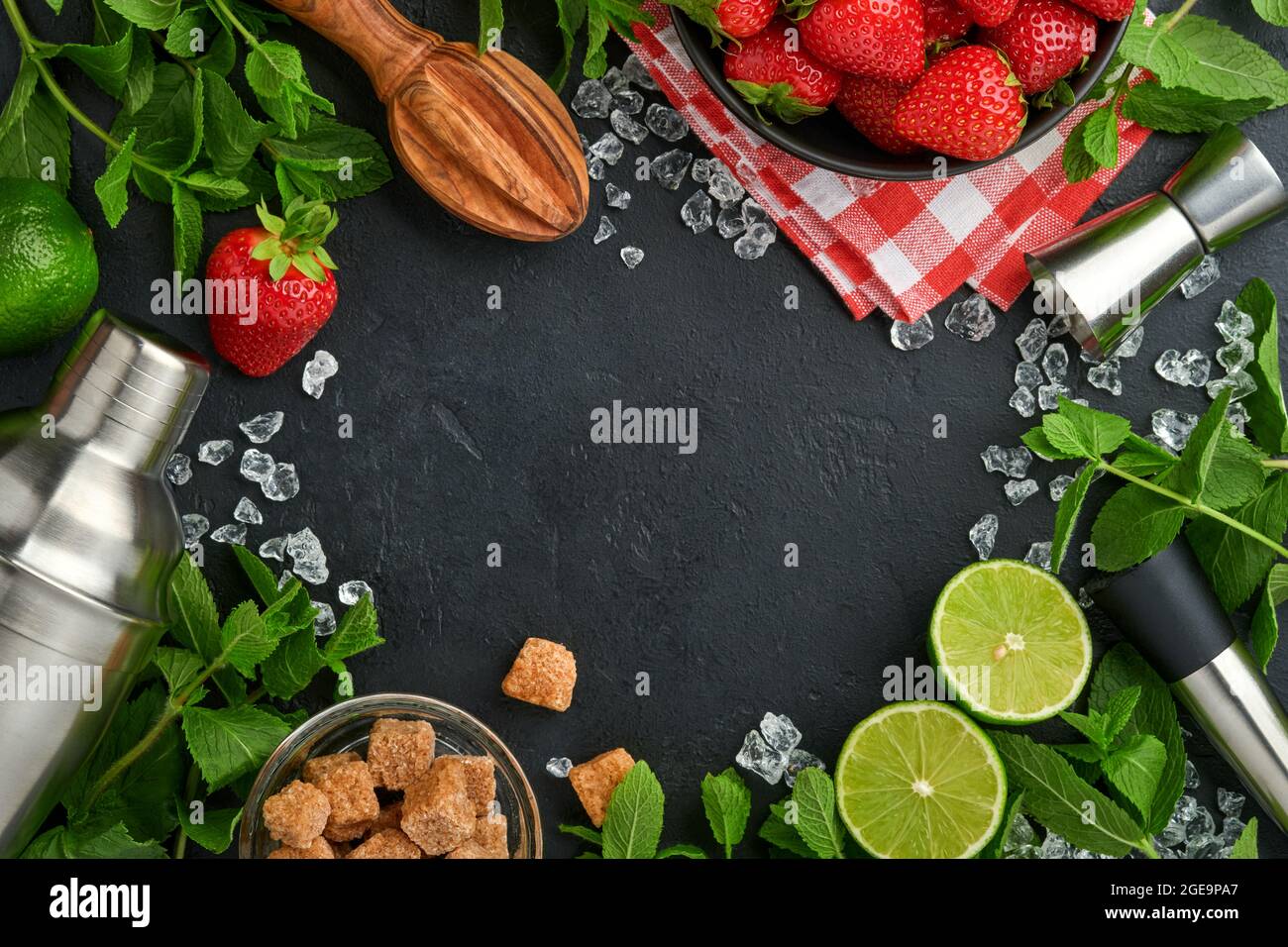 Aliments ingrédients frais pour préparer de la limonade, de l'eau de détox infusée ou un cocktail. Fraises, lime, menthe, basilic, sucre de canne, glaçons et shaker sur bla Banque D'Images