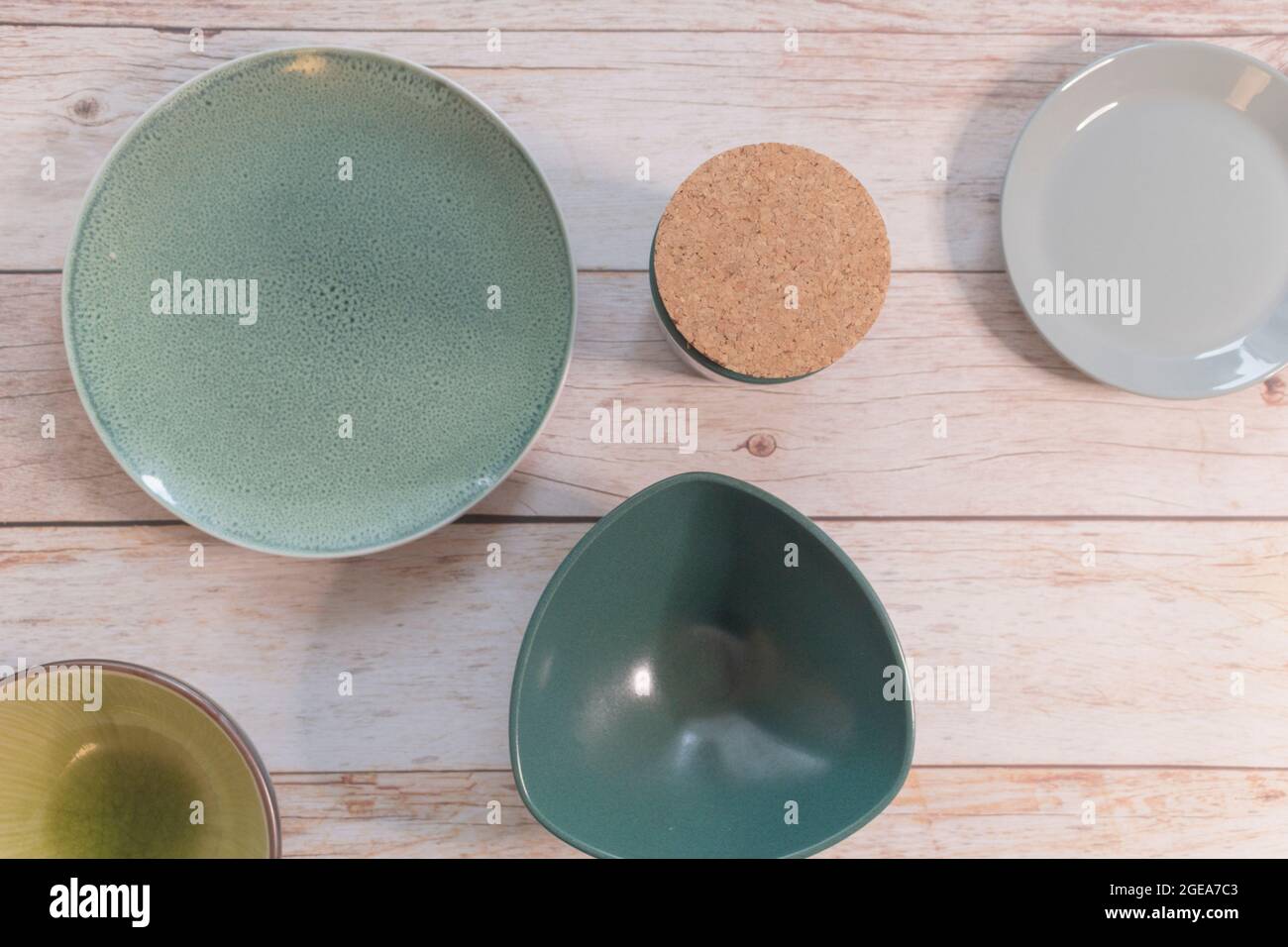 Porcelaine turquoise, verte et jaune, assiettes et bols en céramique sur fond de bois. Vue de dessus, espace pour le texte, conception de la mise en page de l'article. Banque D'Images